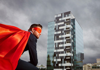 Businessman in a superhero costume against a business building b © Studio Romantic