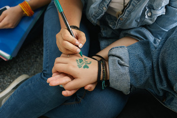Close up of a girl drawing a girlfriend's hand