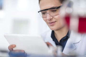 Scientist working in lab looking at tablet