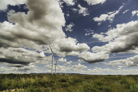 windmills working with a cloudy sky