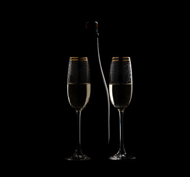 Silhouette of a bottle of champagne and two glasses on a black background.