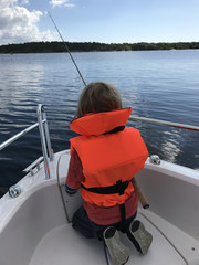 Youngster fishing from boat