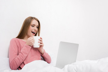 smiling woman with coffee and laptop