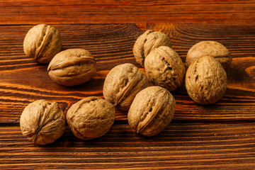 A few ripe walnuts on an old wooden background