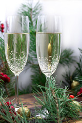 Christmas composition, champaign glasses, pine branches, red berries, golden balls