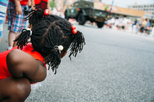 Cute African-American in USA Flag Colors Outfit Girl at a Parade