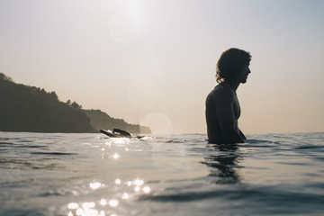 Surfer sits relaxed on his surfboard