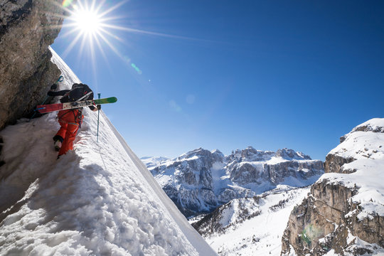 A skier is climbing a mountain of the Dolomites in Northeastern Italy.