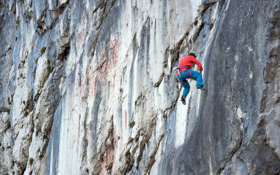 A mountain climber is hanging on the wall of the one of the Barmsteine rock towers, which are part of the Hassel Mountains in the Bavarian Alps between Austria and Germany.