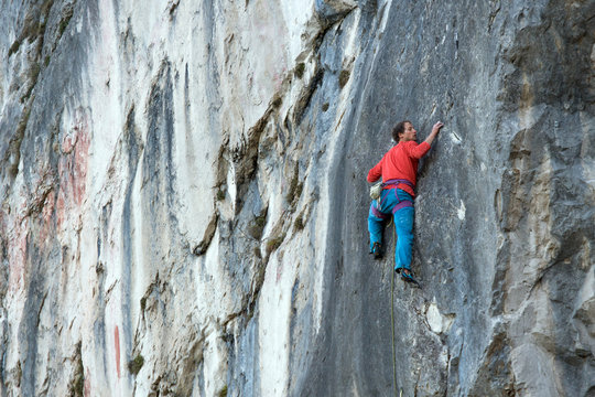 A mountain climber is hanging on the wall of the one of the Barmsteine rock towers, which are part of the Hassel Mountains in the Bavarian Alps between Austria and Germany.