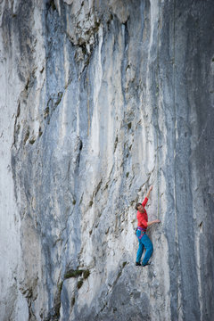 A mountain climber is hanging on the wall of the one of the Barmsteine rock towers, which are part of the Hassel Mountains in the Bavarian Alps between Austria and Germany.