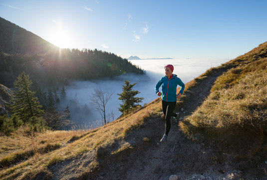 A young woman does mountain running or a trail run at the beautiful Nockstein mountain in Salzburg, Austria.