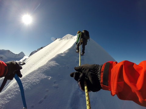 A mountaineer climps his way to the peak of Piz Bernina in the Swiss Alps.