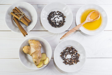 Spices, citrus, honey - ingredients for mulled wine on a white wooden background.
