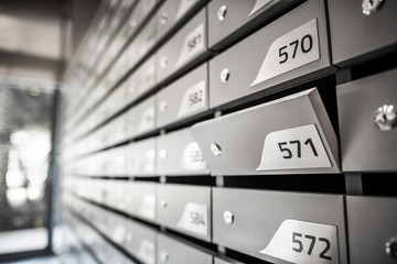 Mail boxes filled of leaflets and letters. Shallow DOF,Mailboxes and Lock in Rows at Entrance.