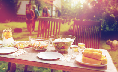 people coming to table with food at summer garden
