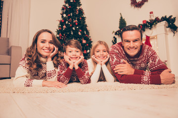 Four attrctive bonding relatives, at home, married couple of brunet and brunette haired, excited siblings, in knitted cute traditional x mas costumes, in socks, noel is here!