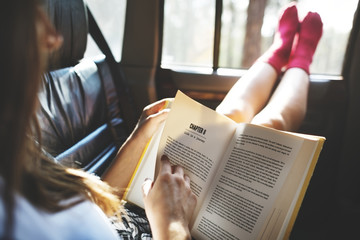 Girl reading a book in a car