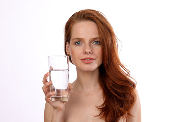 Hübsche rothaarige Frau hält ein Glas Wasser