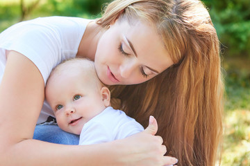 Happy beautiful mother and baby daughter or son