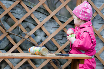 Dziewczynka bawi się piaskiem na ławce w przydomowym placu zabaw. - obrazy, fototapety, plakaty