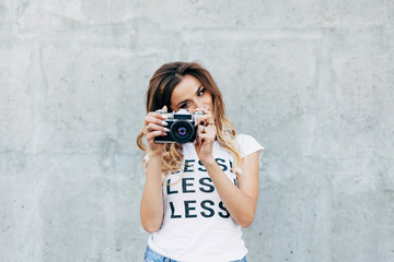 Stylish woman photographer in white T-shirt with word 