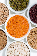 assortment of legumes in bowls, top view closeup