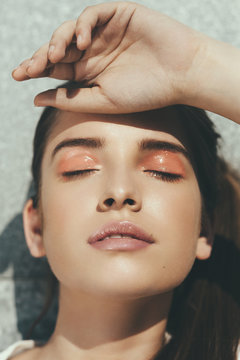 Sunlit face of a young woman with closed eyes