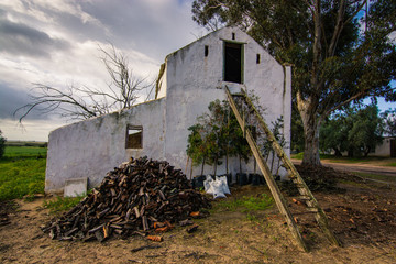 A derelict barn on a farm with rotten stairs leading up to the loft