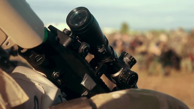 Optical sight on military weapon. Military soldier holding rifle