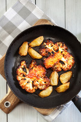 Vegetarian roasted cauliflower steak with herbsand fried potatoes