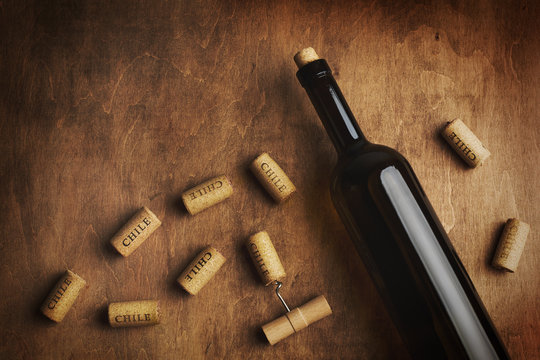 Bottle of wine with wine corks around. The inscription "Chile" on the wine corks. Chilean wine concept. Top view.