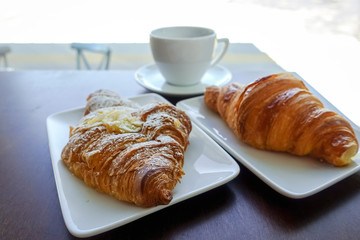 Breakfast with coffee and croissants on table