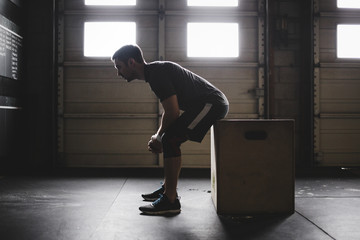 Portrait of young, fit and sweaty man recovering in gym