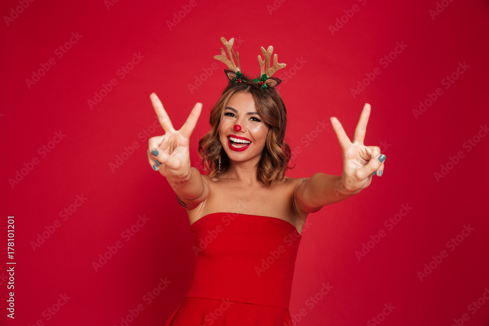 Poster portrait of a joyful happy girl wearing christmas deer costume