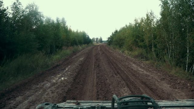 Point of view from moving military car on dirty road