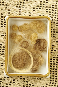 Curls and strains of childrens' hair in a vintage porcelain box