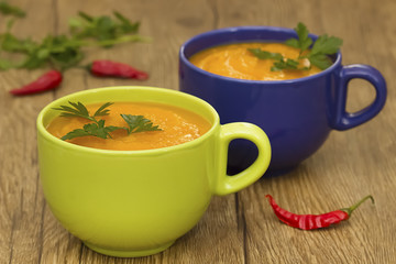 A bright cream soup of pumpkin on a wooden table.