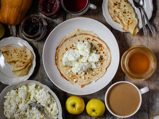 pancakes with cottage cheese and other sweet additives on the wood surface