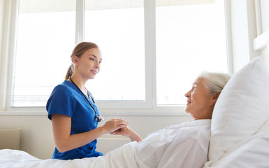 doctor or nurse visiting senior woman at hospital