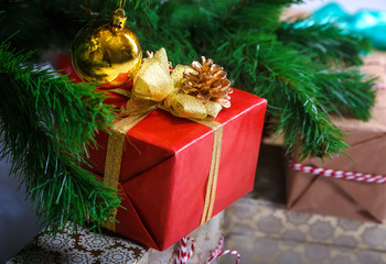Fototapeta na wymiar Decorated gift box under the Christmas tree. Blurred