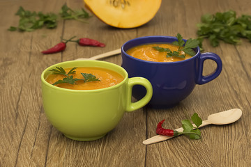 A bright cream soup of pumpkin on a wooden table.