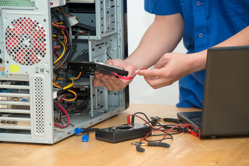 technician working on broken computer in his office