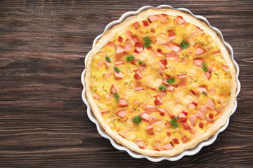 Delicious casserole with sausages in baking dish on table