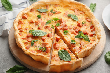 Delicious casserole with sausages on kitchen board