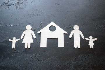 paper family with children near the house on a black background