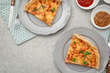 Plates with slices of delicious sausage casserole on table