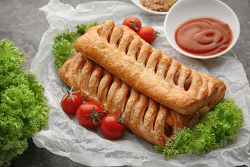 Delicious sausage rolls on table