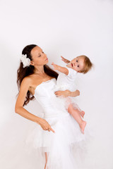 Fototapeta na wymiar Mom and baby girl in white photography in the Studio