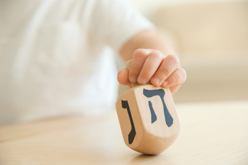 Jewish boy playing with dreidel at home